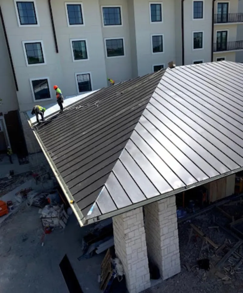 Crew installing standing seam metal roof panels on a commercial project in North Palm Beach